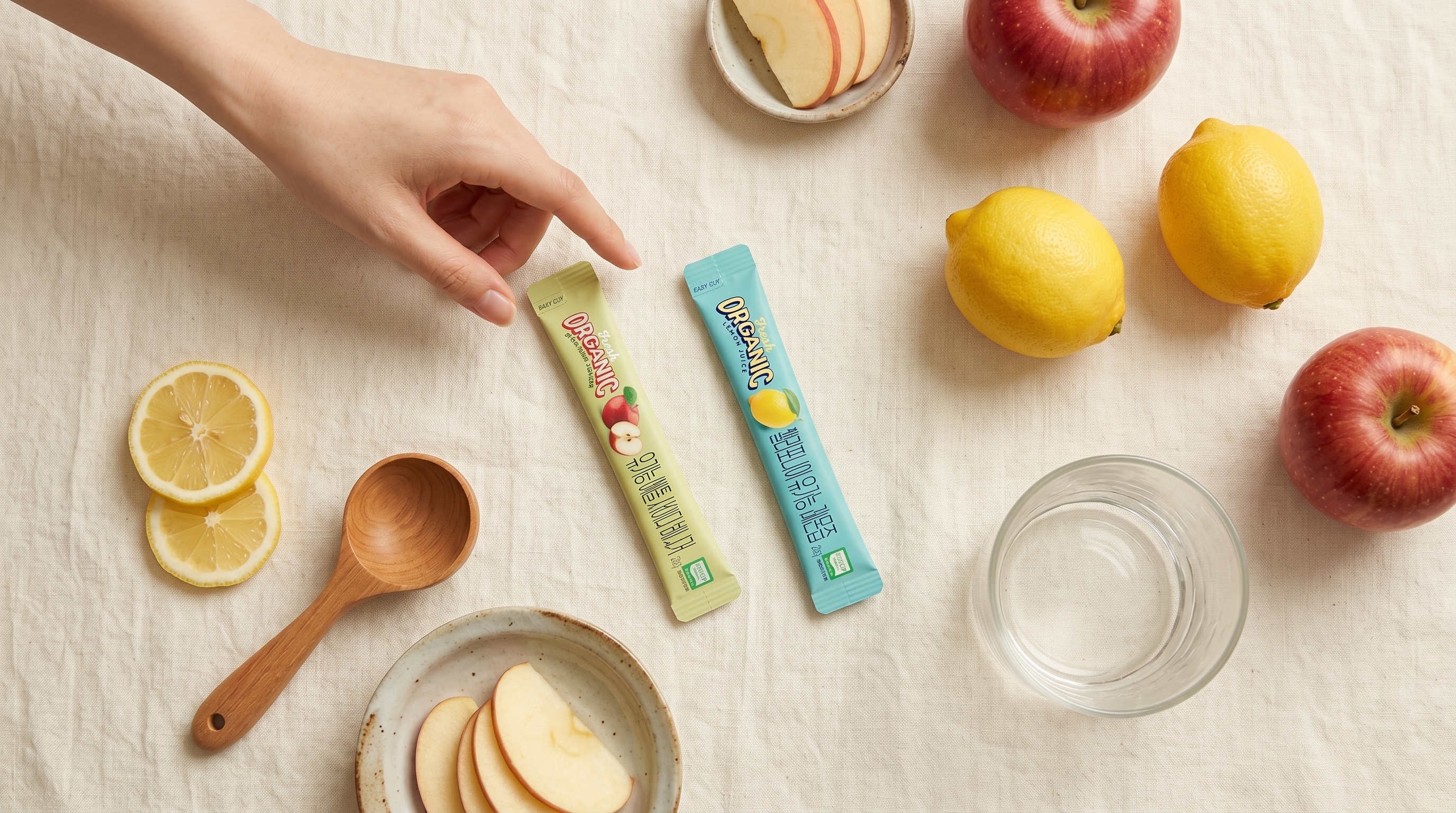 Both ALLBIO sticks flat-lay with apples and lemons — shop the look